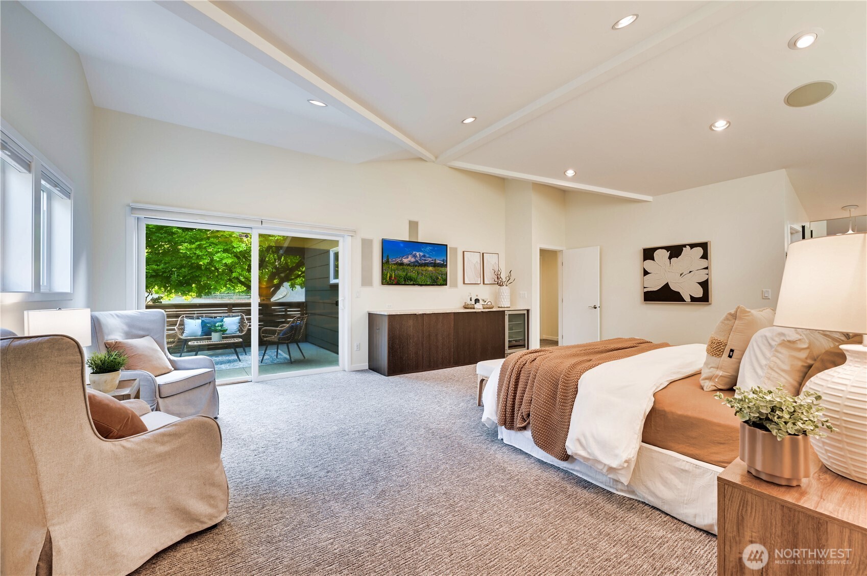 Here you can see the grand space with private patio and flat screen TV over built-in cabinetry with beverage cooler.