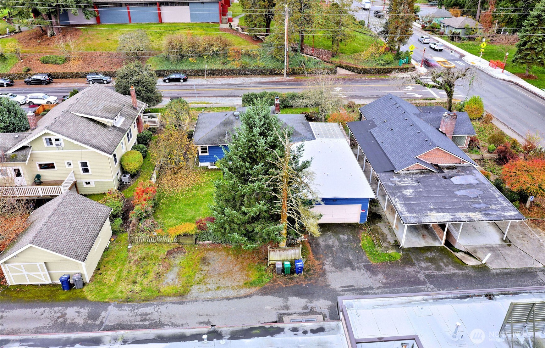 View from alley with 4 parking spots next to fir tree  & garage