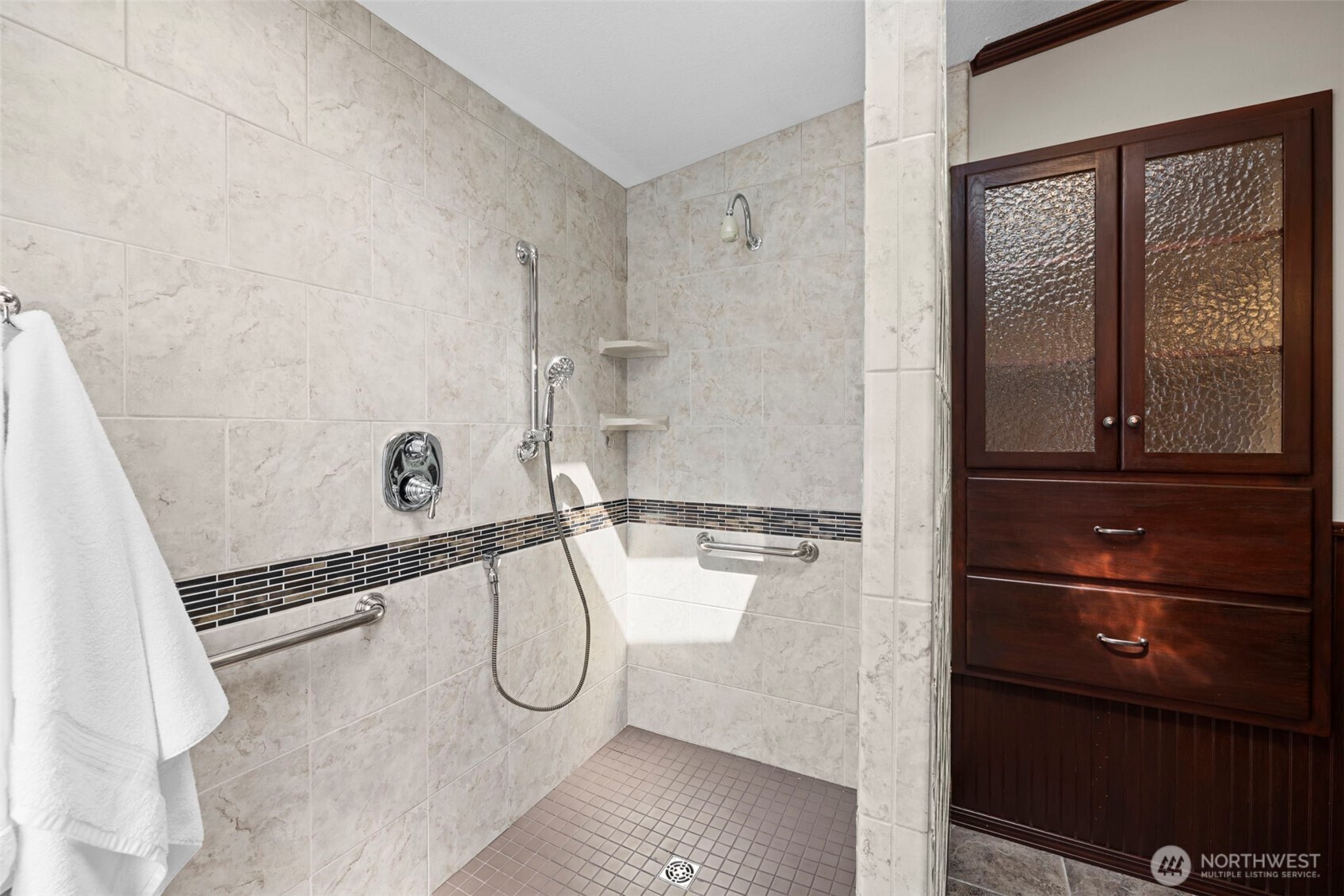 Tile shower floor and surround. Built in cabinetry for extra storage.