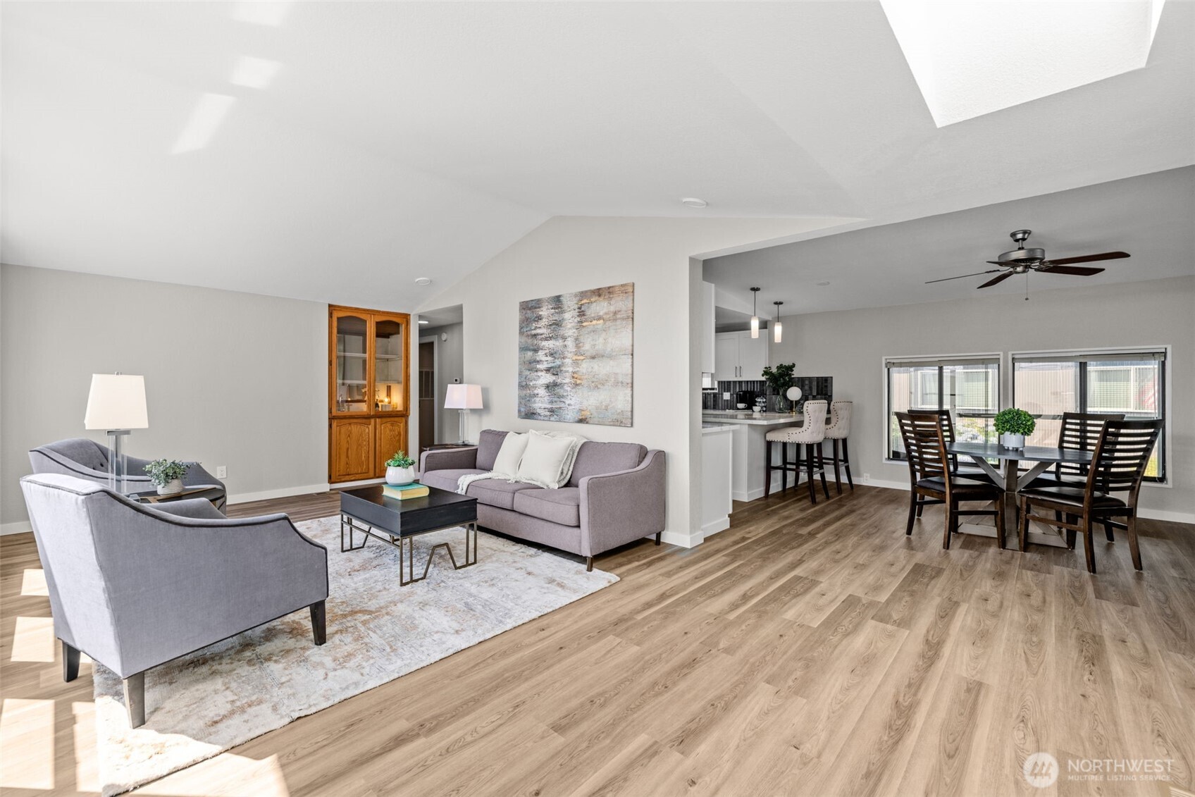 Vaulted ceiling line over living room. New luxury vinyl plank flooring and fresh paint.