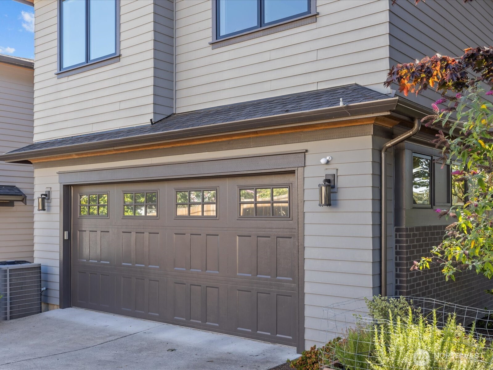 An alley-loaded two-car garage includes an EV charger, combining convenience with modern functionality.