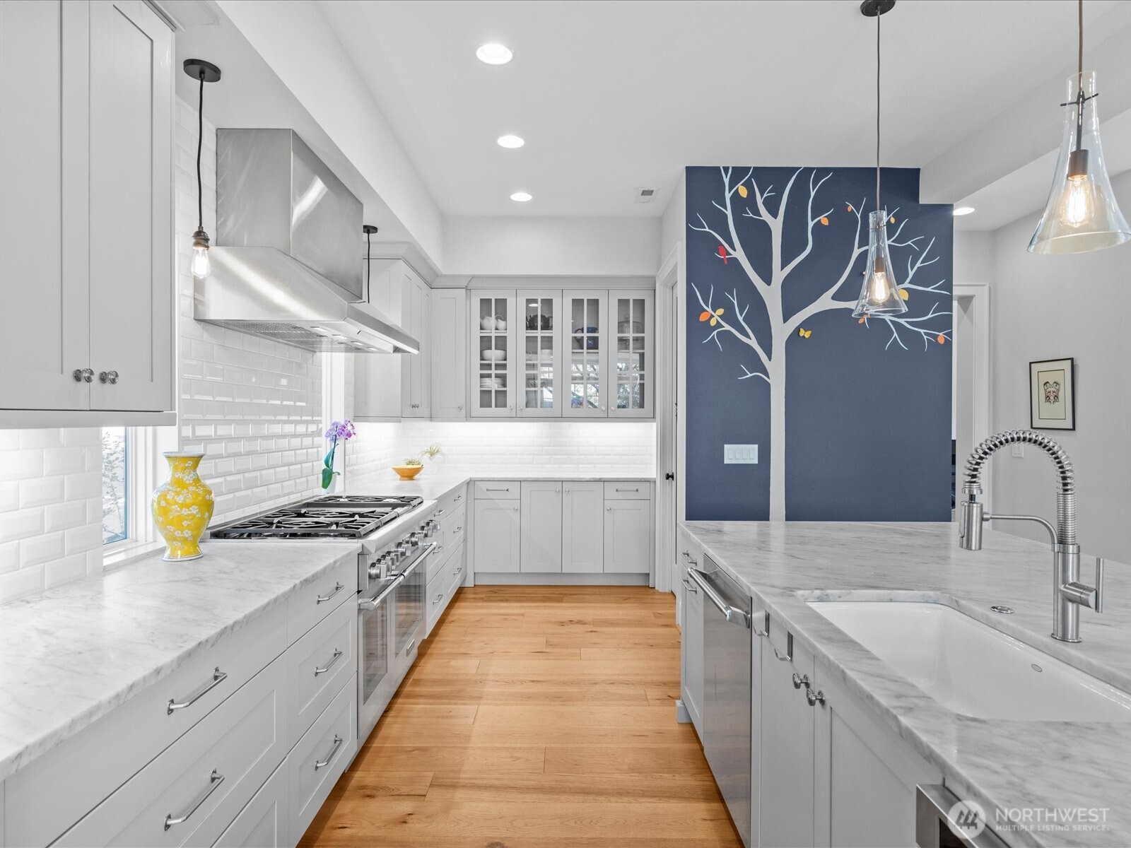 The gourmet, epicurean kitchen showcases a sleek monochromatic palette and is outfitted with high-end designer finishes—offering both style and function for the modern chef.