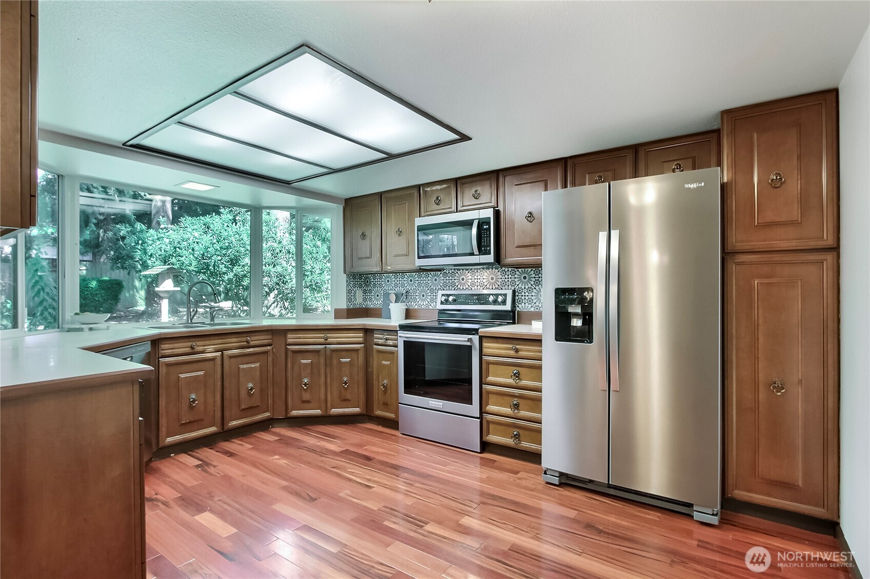 Kitchen has new stainless appliances, The wall of windows makes one feel as if they are outdoors. The backyard is so private, there is no need for blinds.