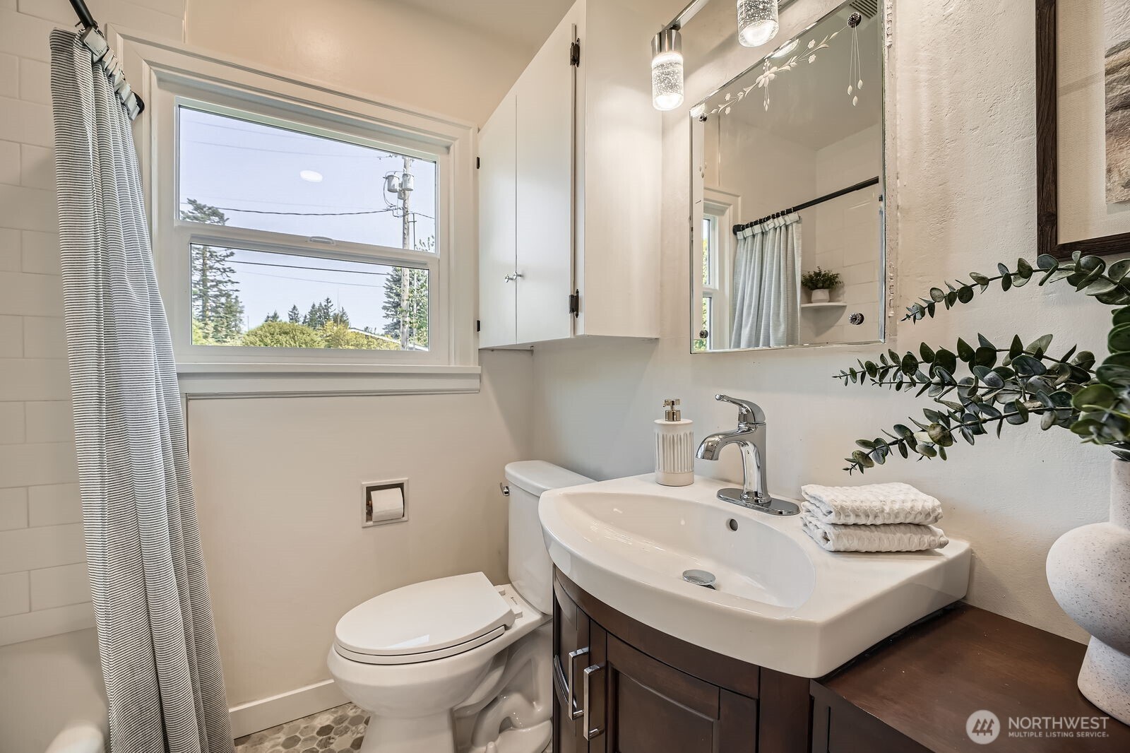 Full bath on main floor includes an oversized tub, new vanity with LED lighting, and an intricate hexagonal floor pattern!