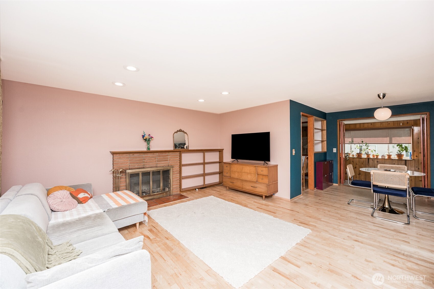 Living area open to the Dining room with hardwood floors, wood burning fireplace and newer recessed lighting added