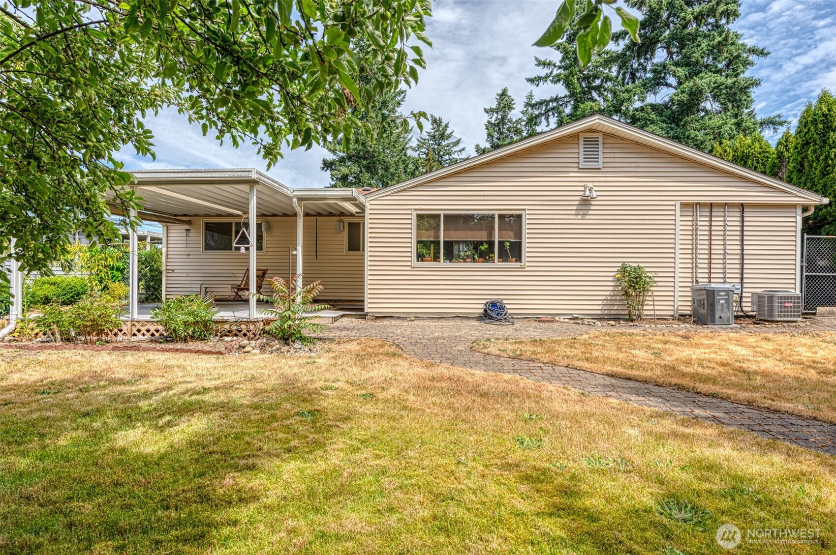 Back exterior of the home. Notice is offers A/C for those warmer days and a spacious covered patio.