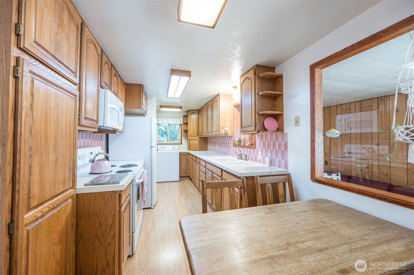 Full kitchen with raised panel wood cabinets. Plenty of counter space and cabinets for your convenience.  Area for seating within the kitchen or just use the dining room