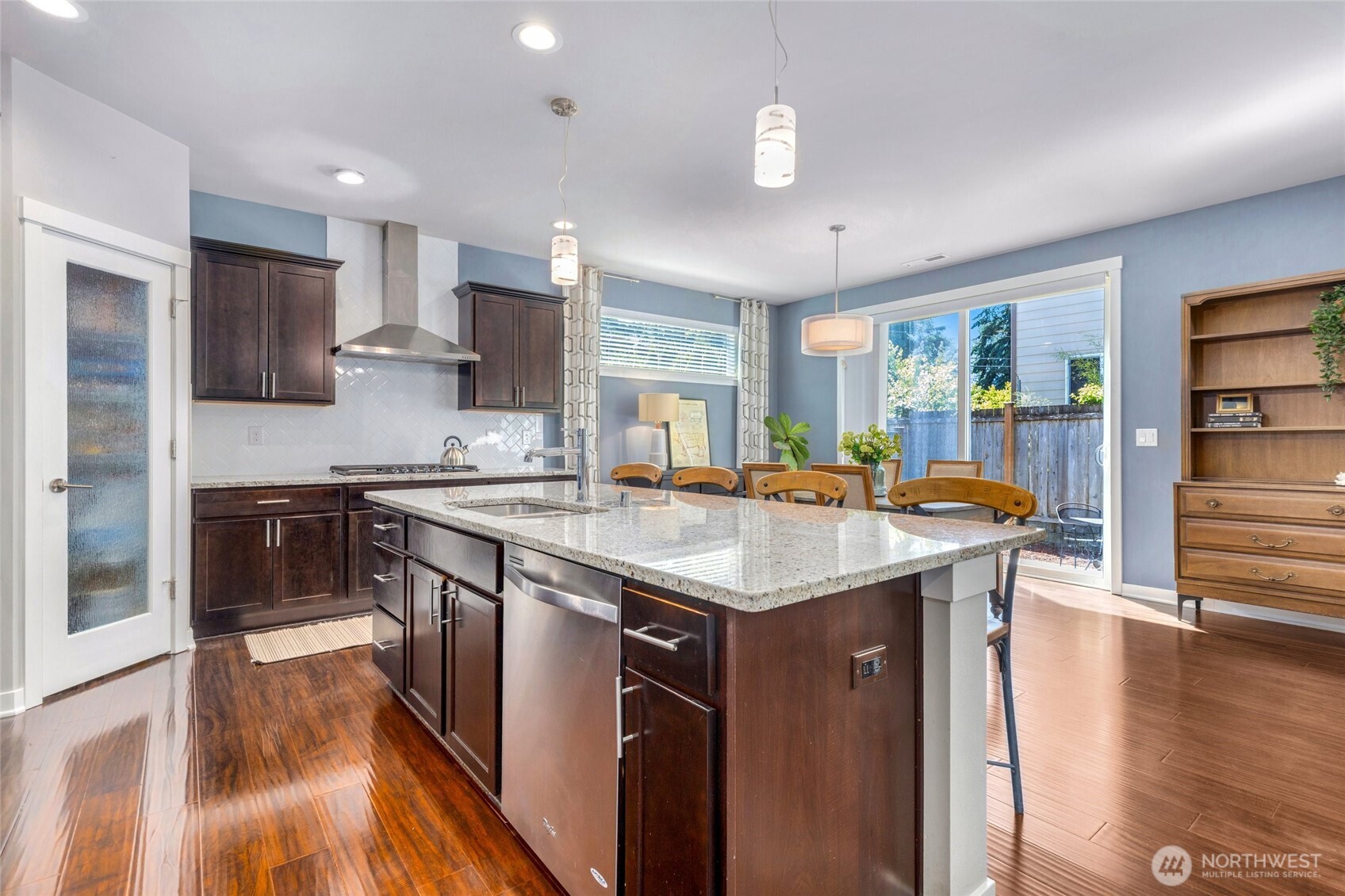 The heart of the home features a spacious kitchen designed for both everyday living and entertaining. A large center island offers plenty of workspace and seating, while the gas cooktop and wall oven make cooking a breeze. A walk-in pantry provides ample storage, keeping everything organized and within reach.