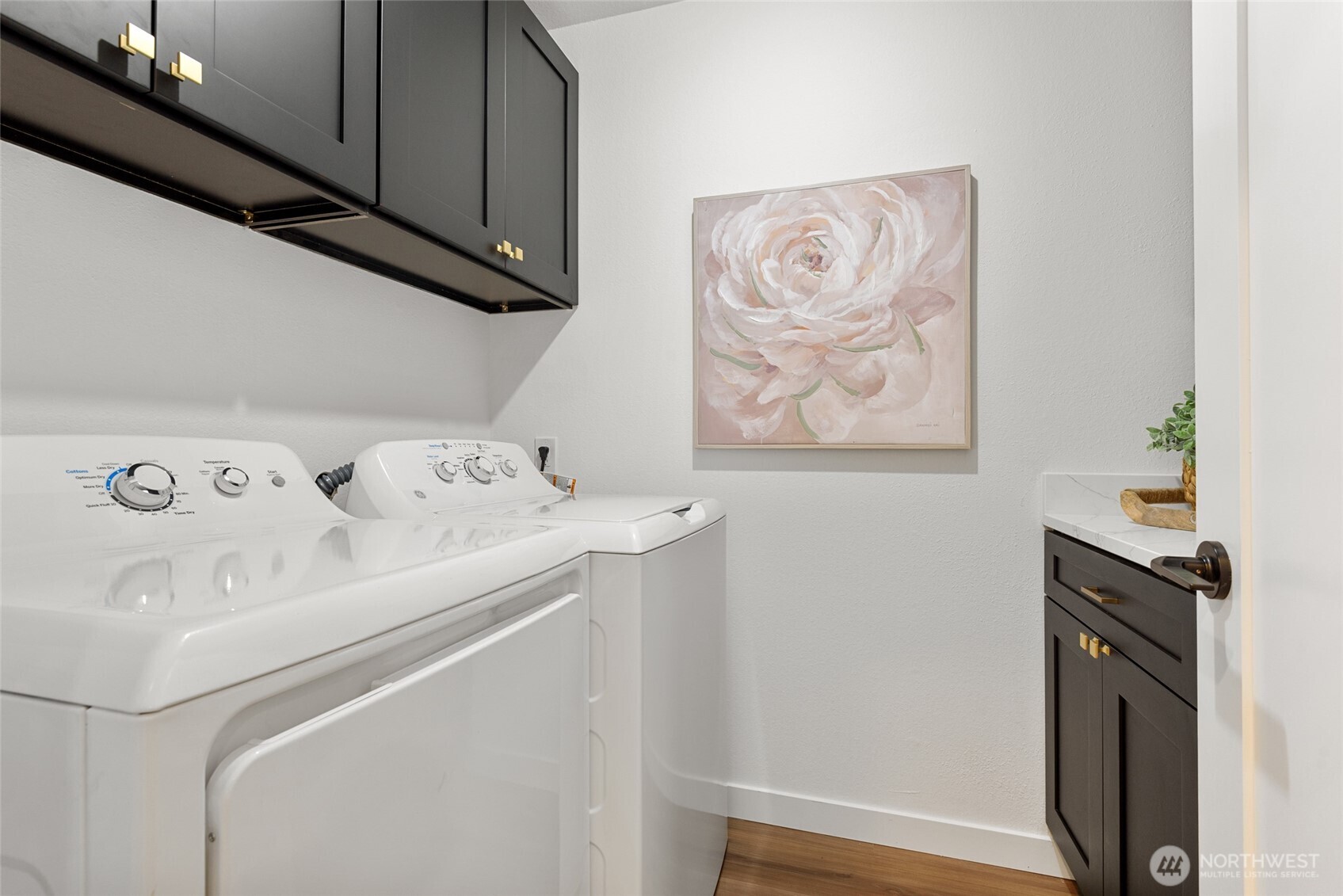 Functional laundry room with updated cabinets and quartz counter tops.