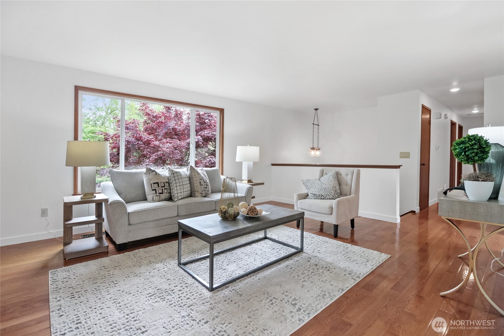 Bright and spacious living room featuring elegant engineered hardwood floors and abundant natural light.