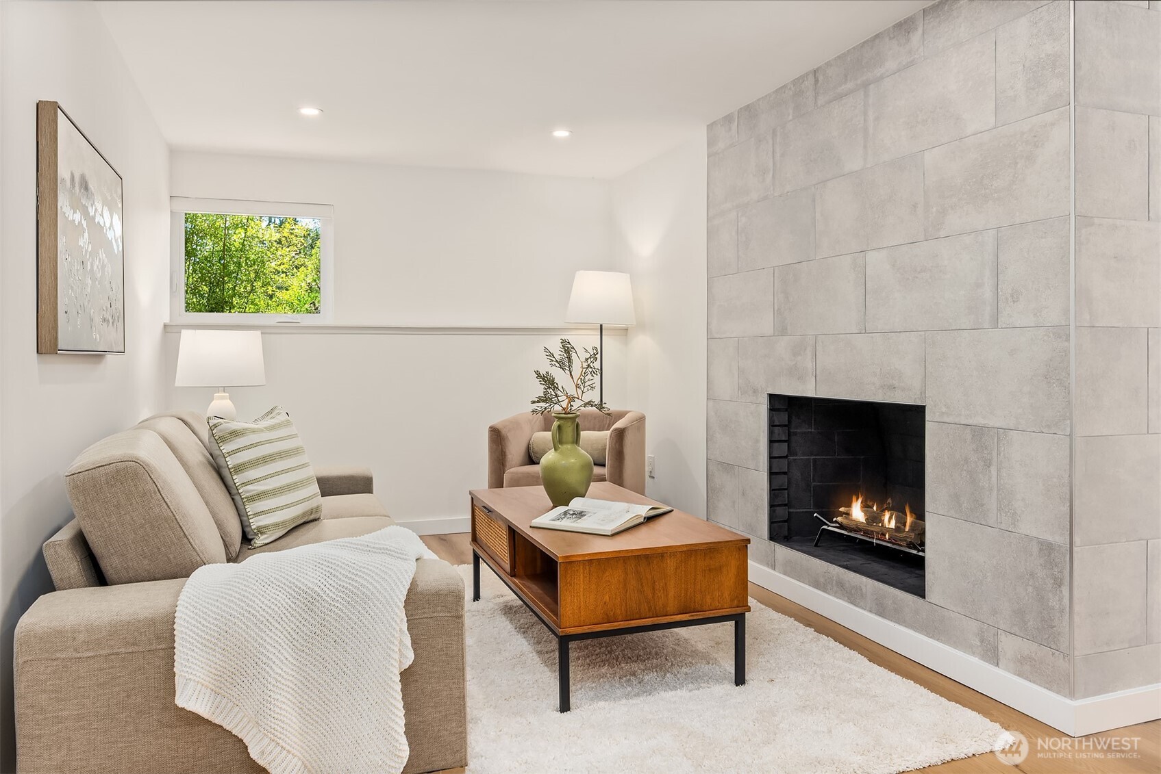A versatile flex space—perfect as a hangout area or home office—features a cozy fireplace and abundant natural light from a west-facing window.