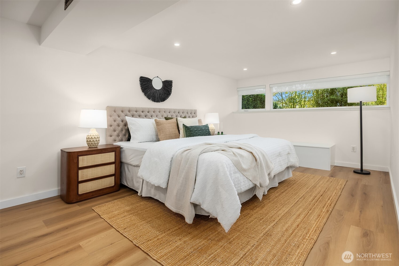 The fourth bedroom, located downstairs, is generously sized and filled with natural light from west-facing windows.