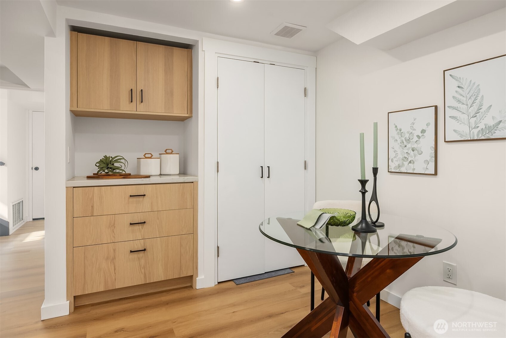 The laundry nook, updated in the 2024 remodel with high-quality custom cabinetry, features a stacked washer and dryer discreetly tucked behind doors—and even offers enough space to double as a cozy sitting area.