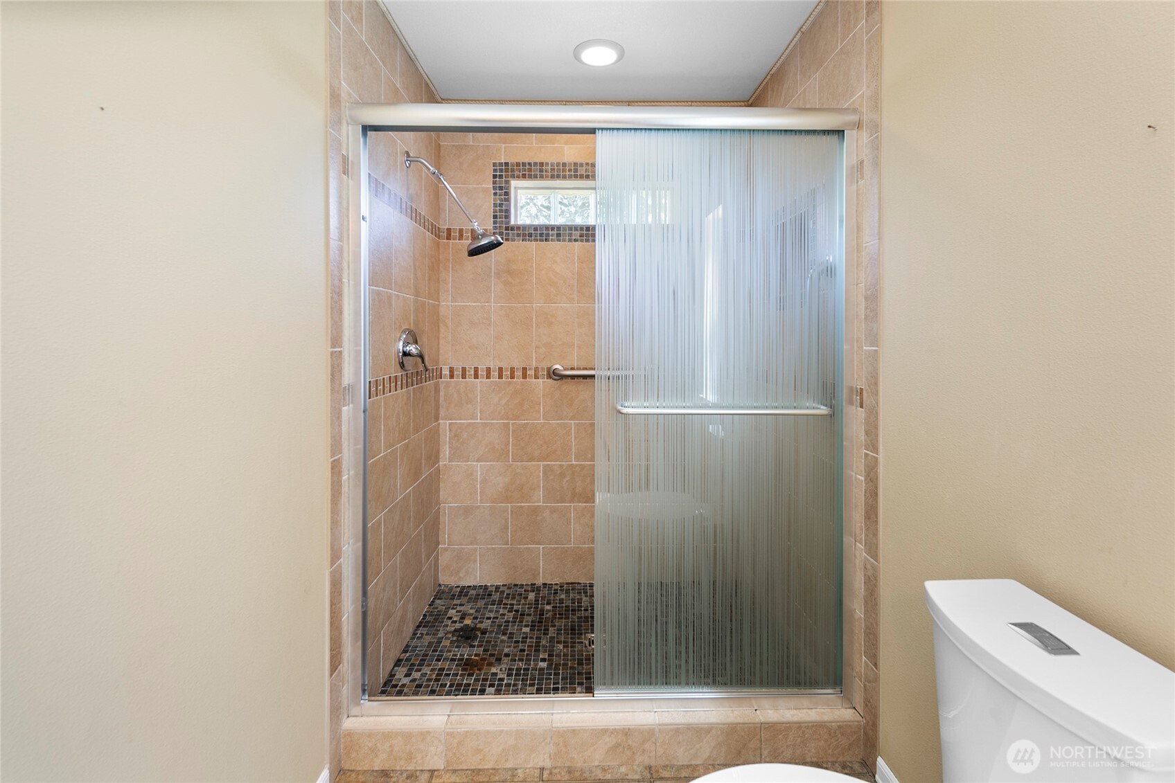 A walk-in closet and ensuite bath with tiled shower bring everyday comfort and function.