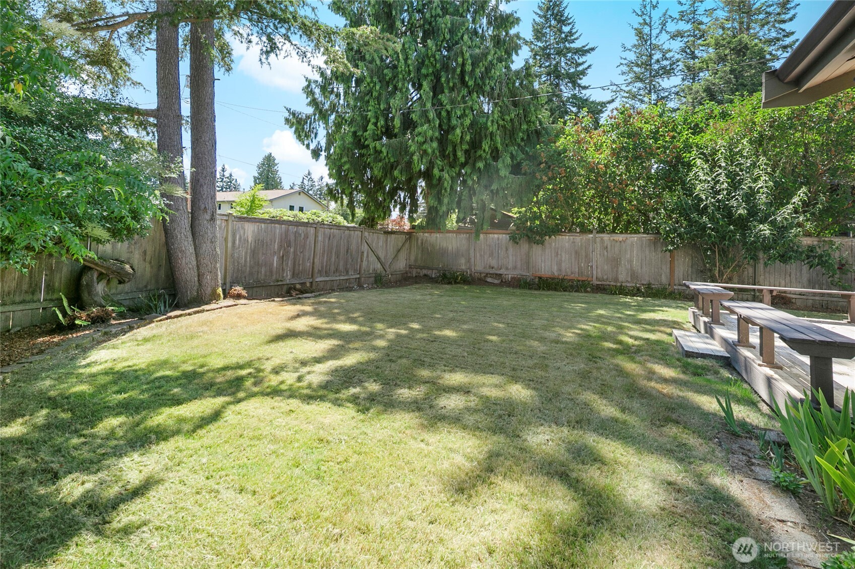 A spacious, flat yard wraps around the home, ready for play or planting.