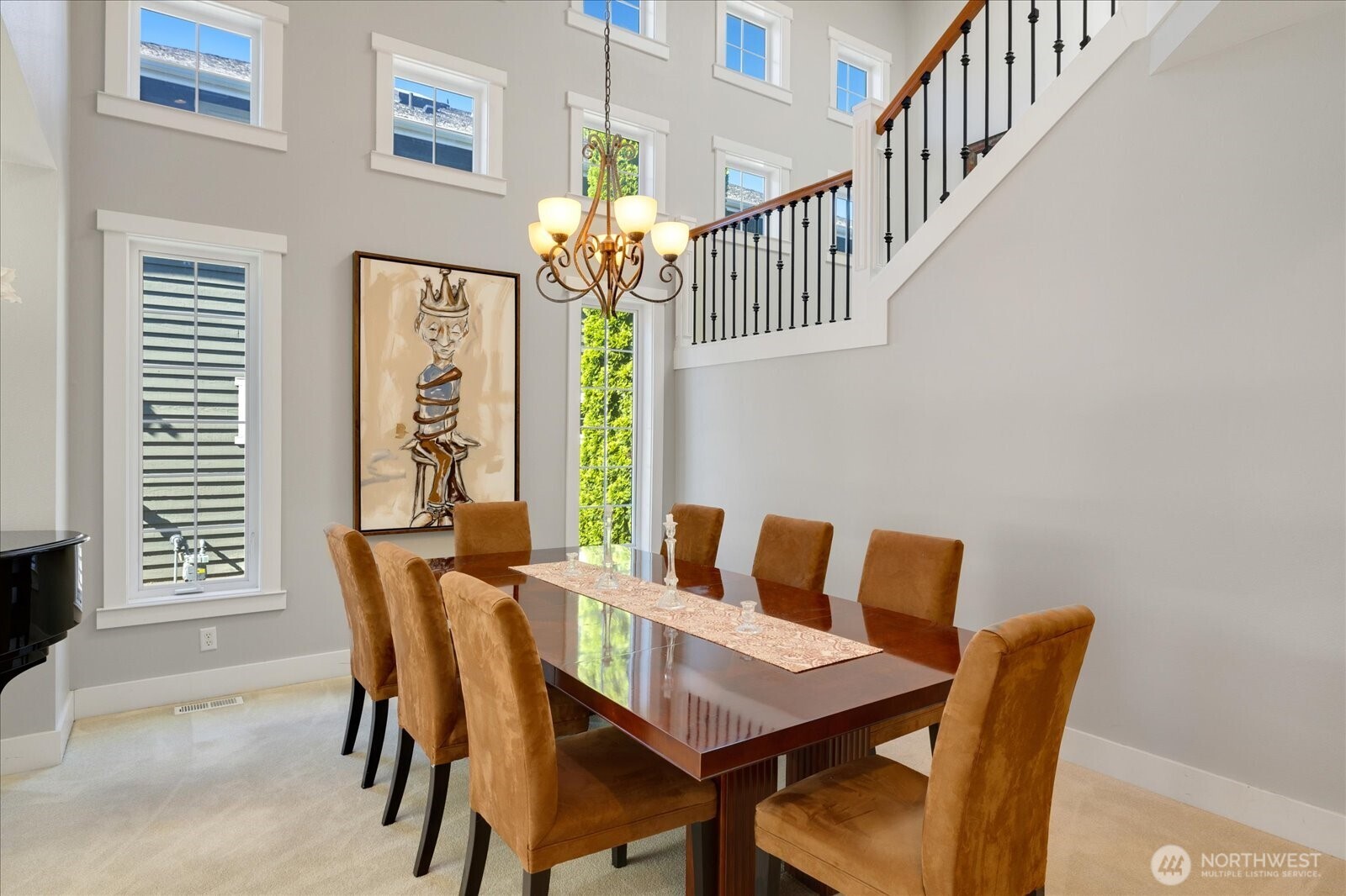 A double story wall of windows provides lots of light and interest in the dining space.