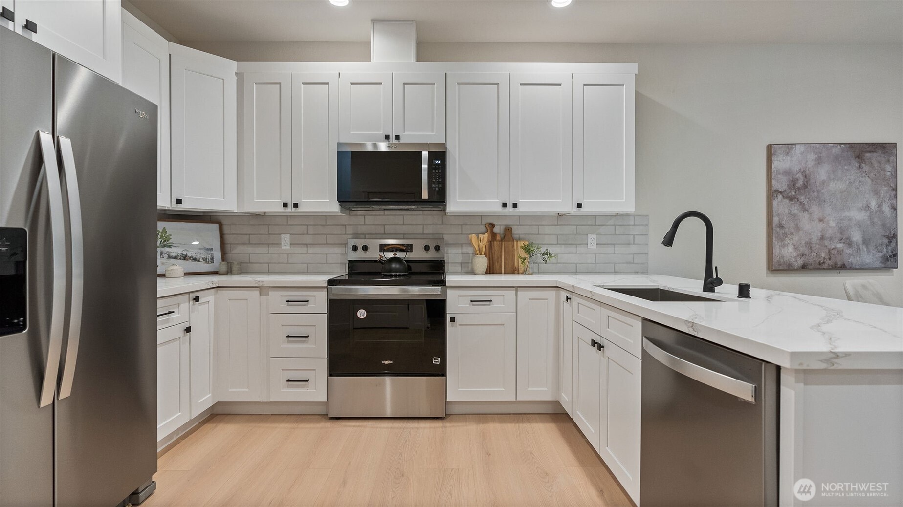 Kitchen has quartz counters and stainless appliances. Fridge included.