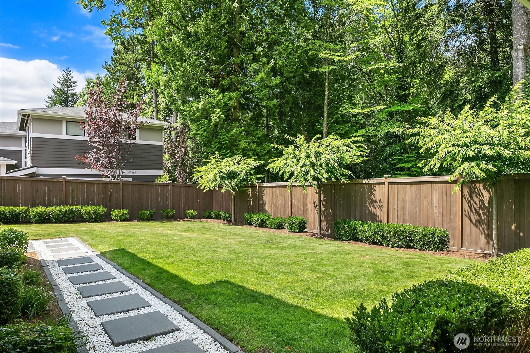 The fenced yard has been recently upgraded with a large, grassy play lawn & paver walkway.