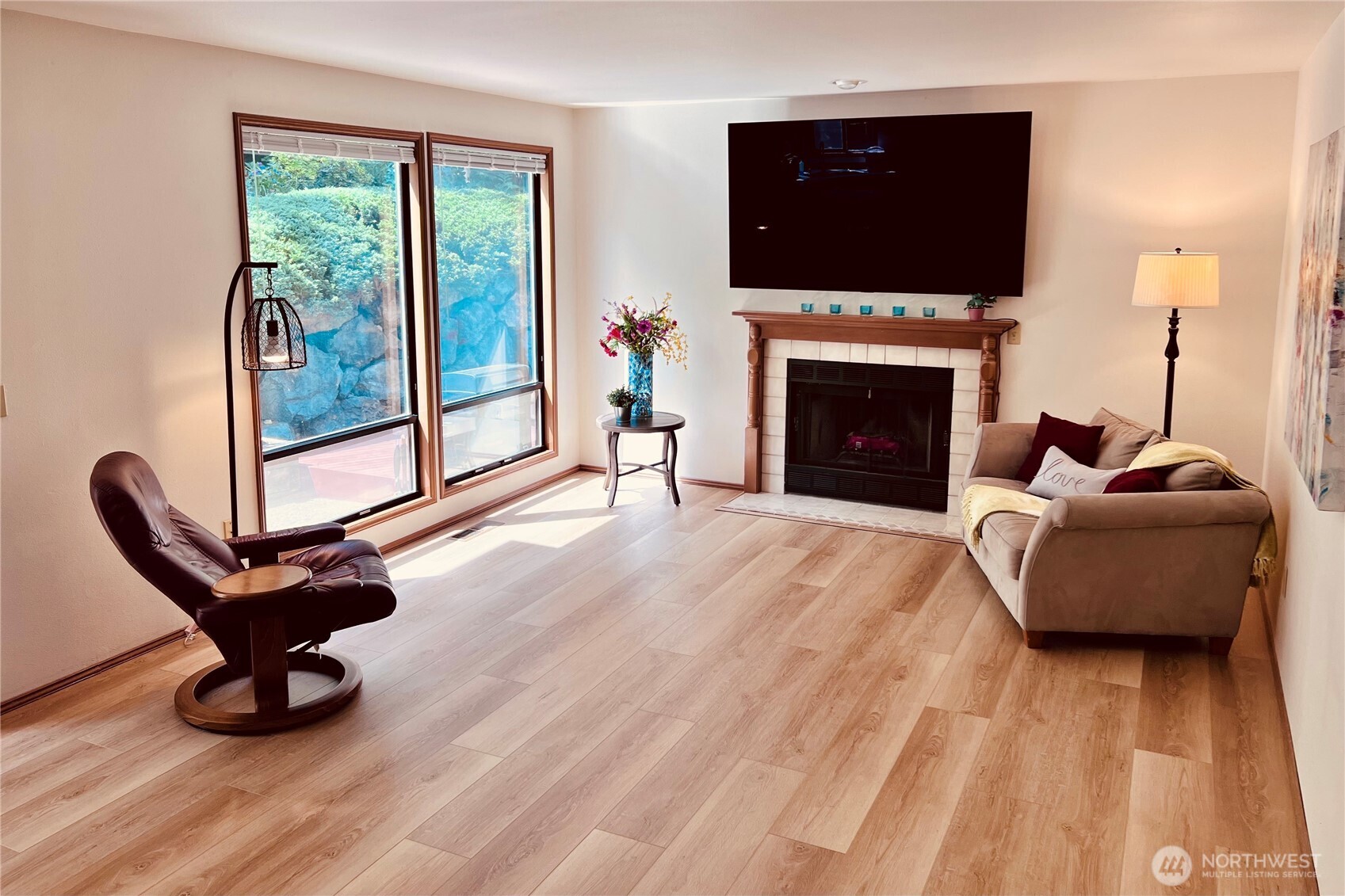 Family room looking west into backyard with large windows. New wood flooring with open living space into kitchen