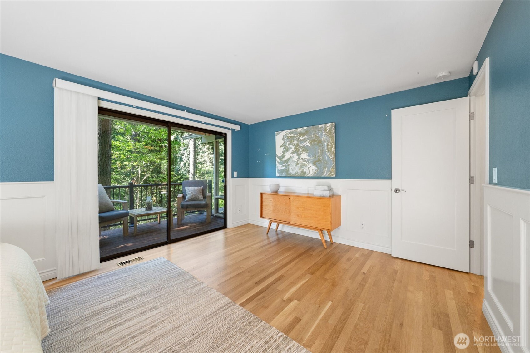 Crisp hardwood floors enhance the feel of this spacious Primary Suite, complemented by peaceful views and direct access to the private deck.