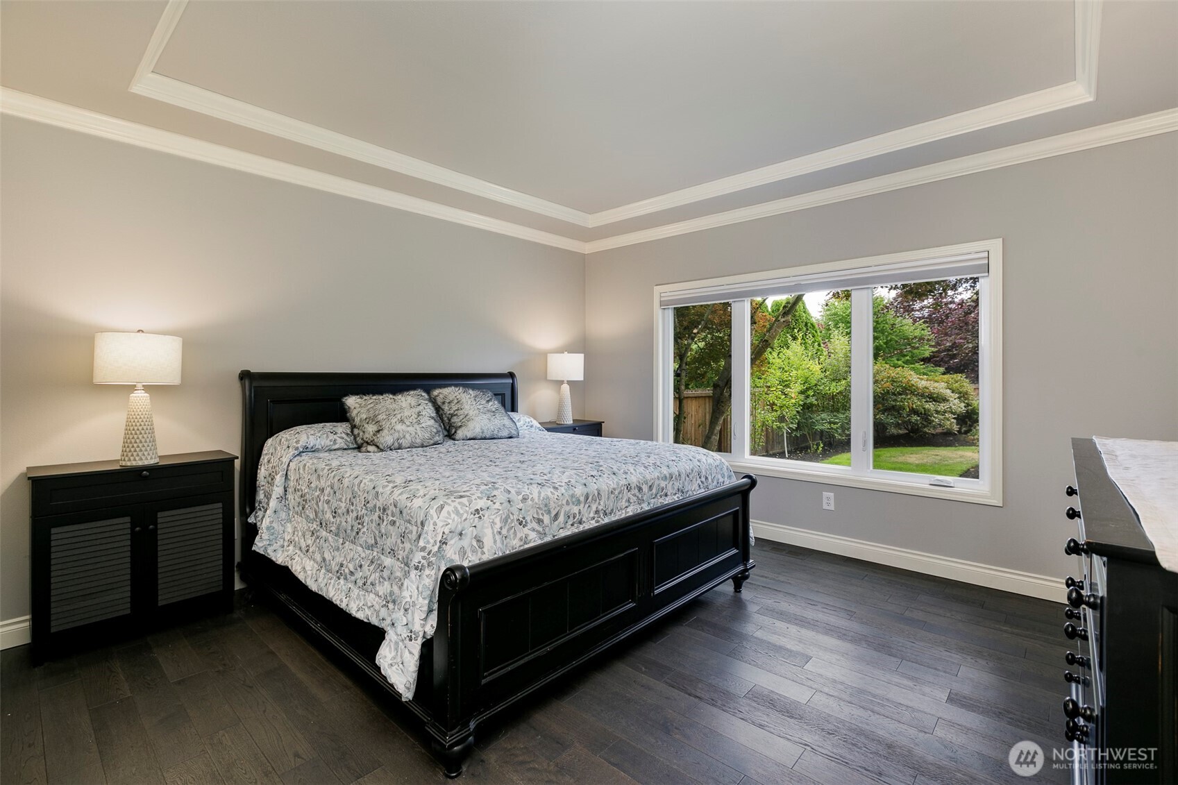 Main floor primary suite is spacious w/ coffered ceiling, crown molding & large windows to enjoy the backyard views
