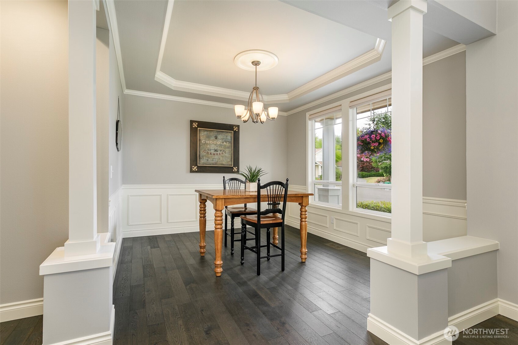 Spacious dining room w/ coffered ceilings, crown moldings & wainscot wall design