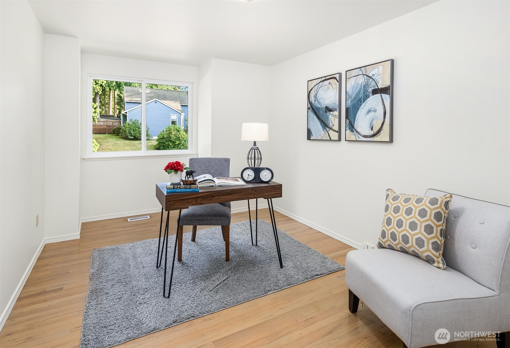 One of 3 upstairs bedrooms, styled as a home office. Floors are hardwood.