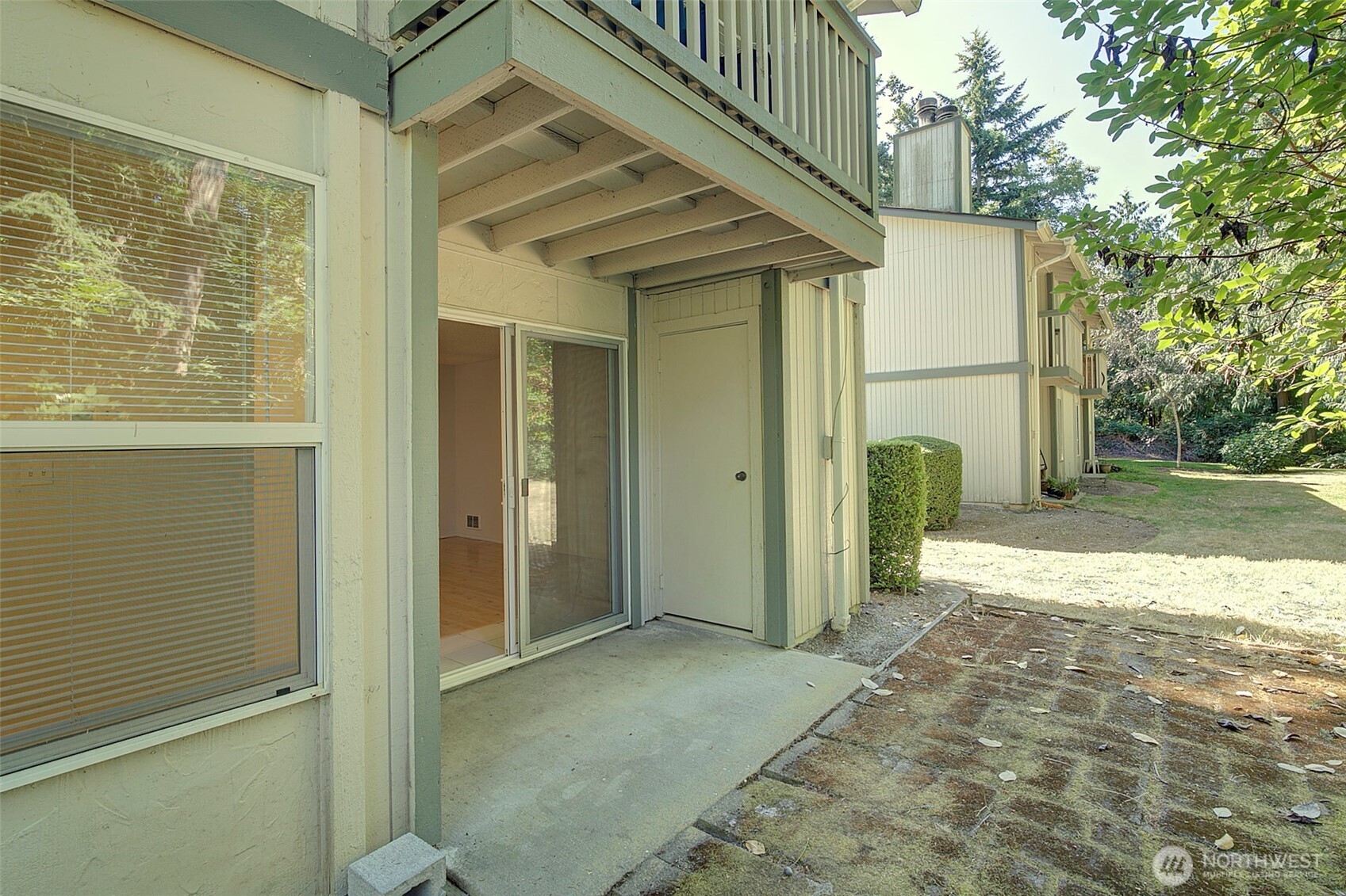 the condo exits to this back patio, and faces a green area. Storage room is on the south side of the patio,