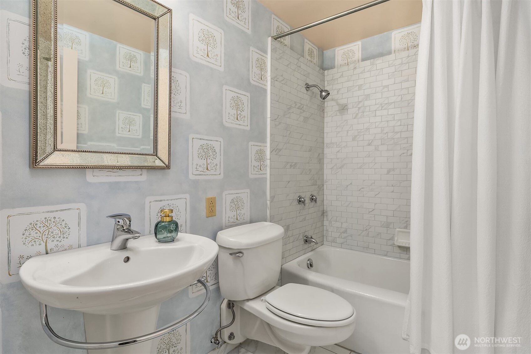 The third bathroom on the main-floor third features a full tub and updated tile surrounds for a clean, modern feel.