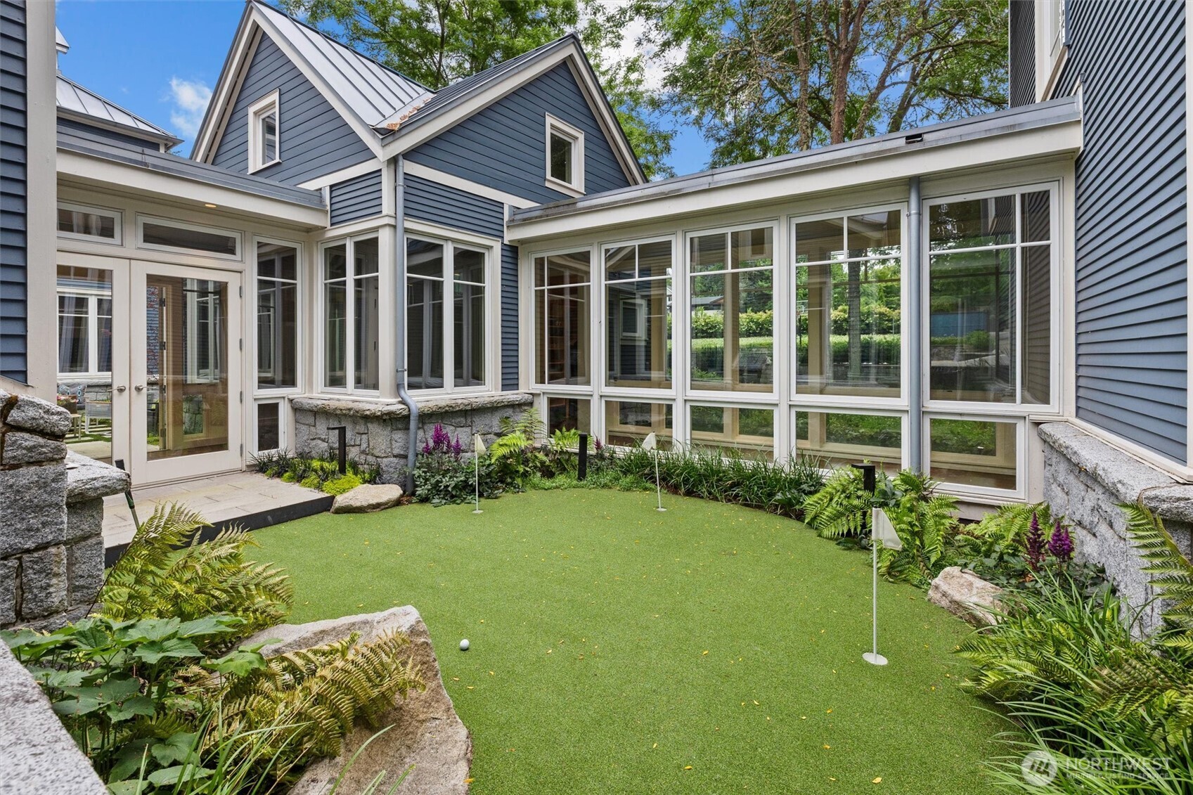 Putting green in courtyard surrounded by hallways and rooms in home