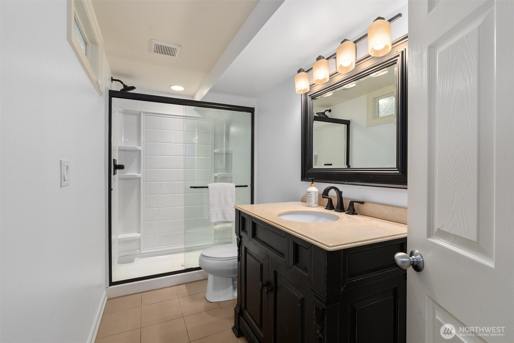 Elegant lower-level ¾ bath featuring stylish finishes and a walk-in shower—perfect for guests or added convenience.