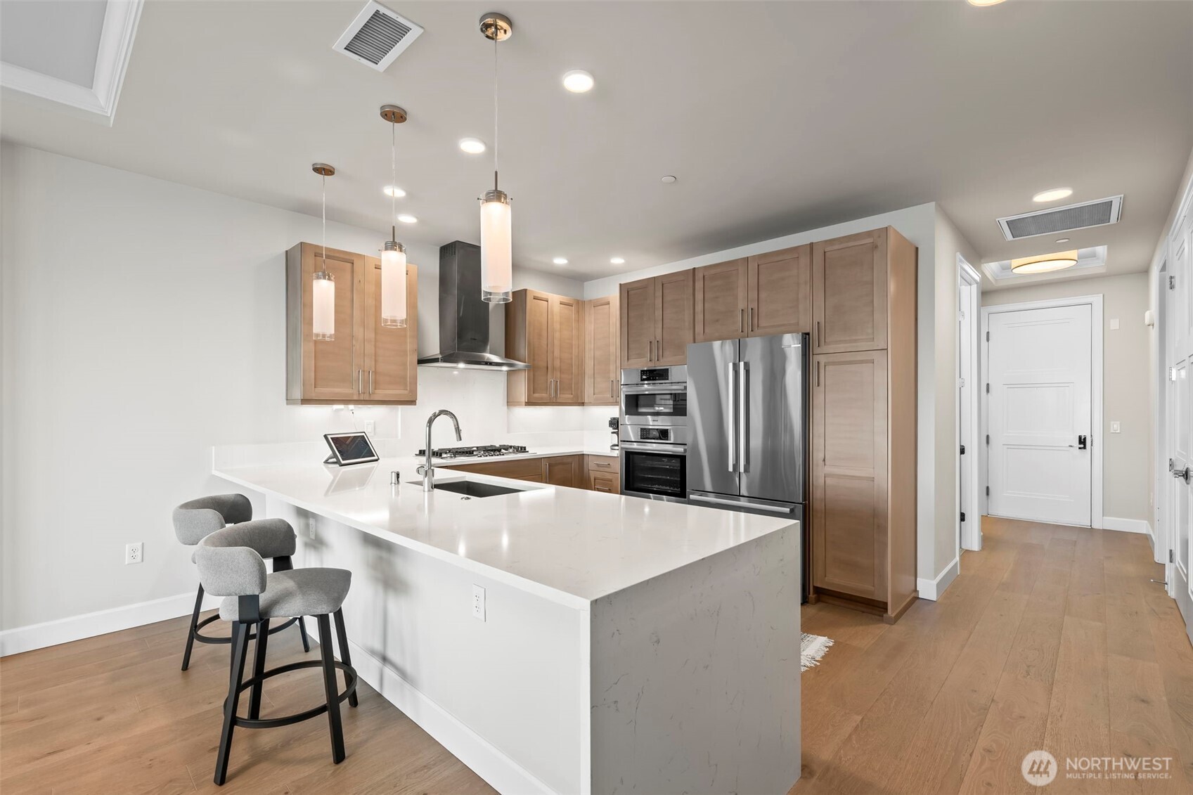 Quartz countertops with luxe waterfall design and plenty of seating available to entertain your guests