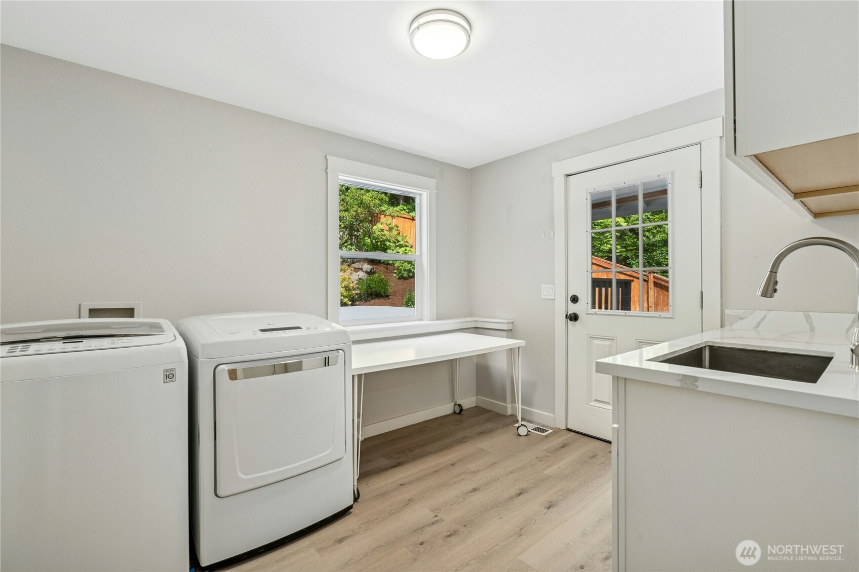 Huge laundry room with door to backyard, sink & folding table