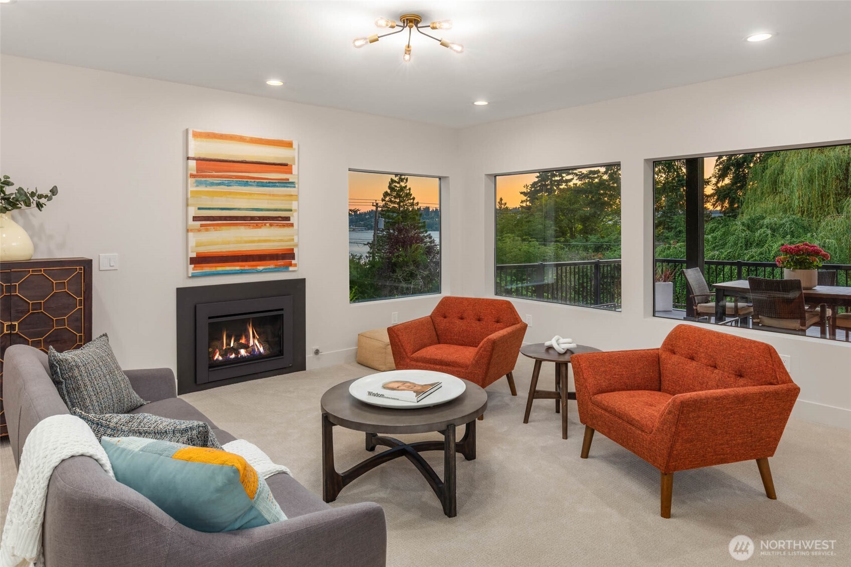 The garden level is truly special! Just like the rest of the home, there are gorgeous views from nearly every room. This is the main room which includes a fireplace and large adjoining deck, and more space beyond. You'll see that next!