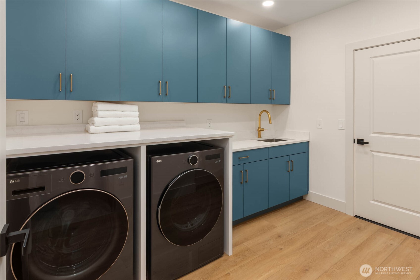 This home has two laundry areas: one in the primary suite, and this one on the garden level. This is a brand new space and is not included in the stated square footage. The space was taken from a very large crawl space that you just have to see to believe! The door in this photo leads to the rest of the crawl space which could potentially provide room for other ideas of interest.