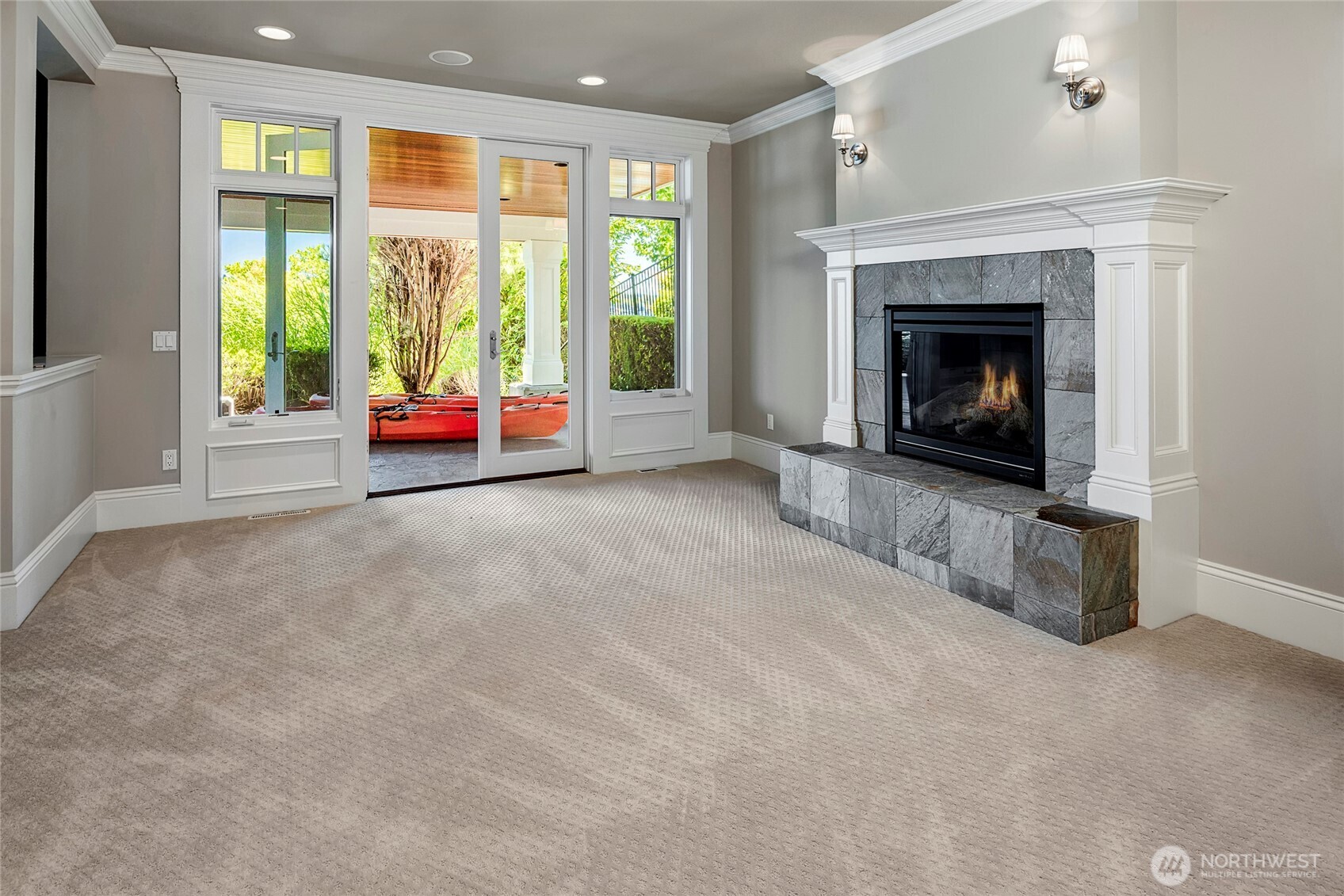 The lower level shows off an oversized rec room with the 4th and final gas fireplace, with another set of French doors leading to the covered patio and walkway to the waterfront.