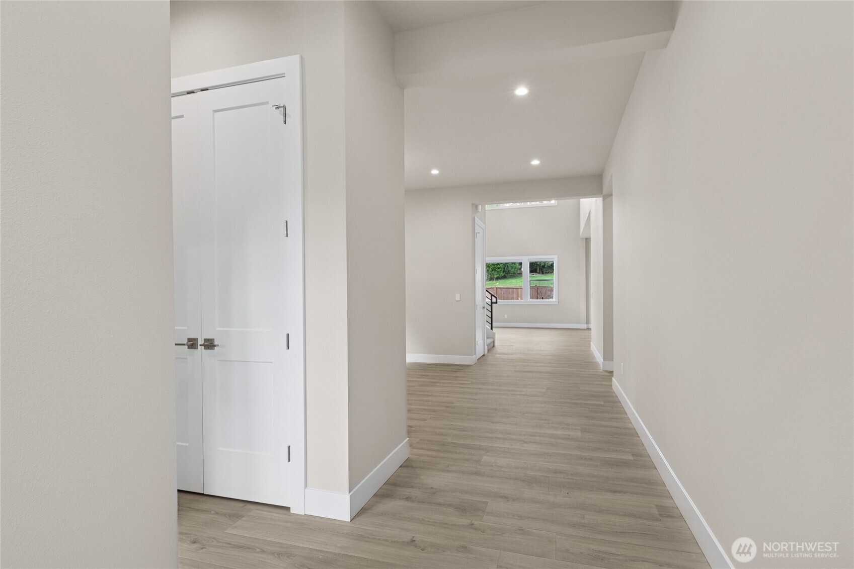 Inviting entry hallway with wide-plank flooring, recessed lighting, and clean sightlines into the main living area. Thoughtful layout offers a seamless flow from the front door to the heart of the home.