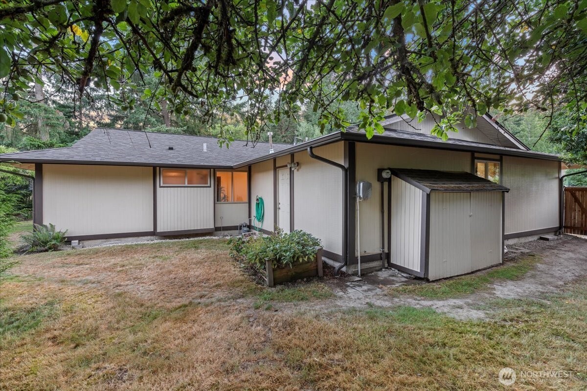 Space behind the garage with apple tree, planting box and room for storage on the side yard