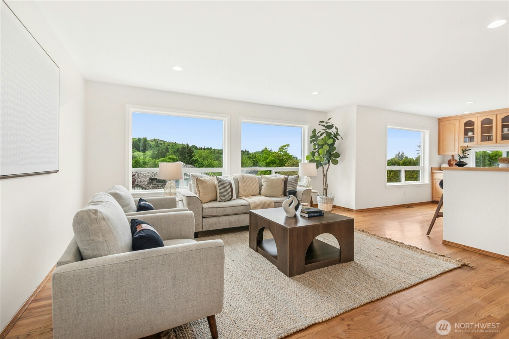 Main floor open concept Family Room and Kitchen with space to gather in small groups or host large ones. The large, sunny, southern-facing windows look over the rolling green hills of the Newcastle Golf Course while letting in plenty of natural light.
