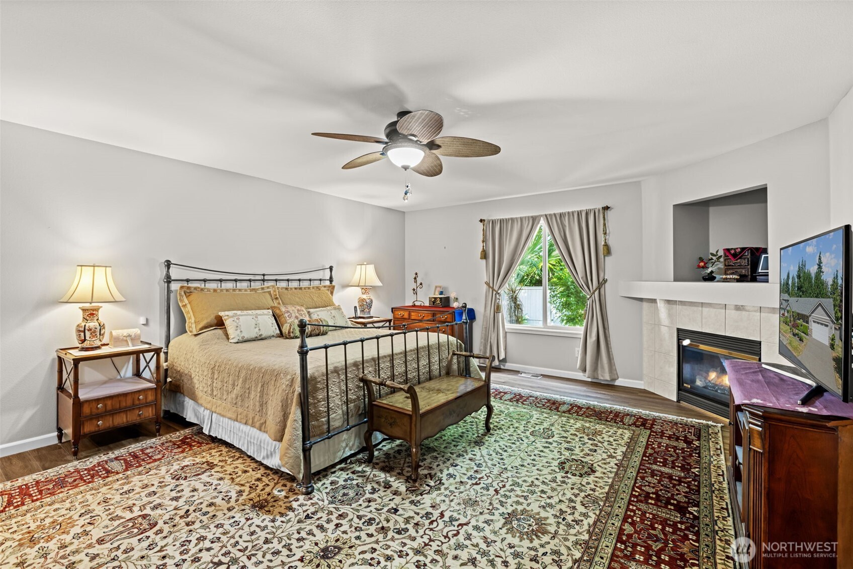 Rich warm flooring color, ceiling fan, fireplace, TV and component niche.