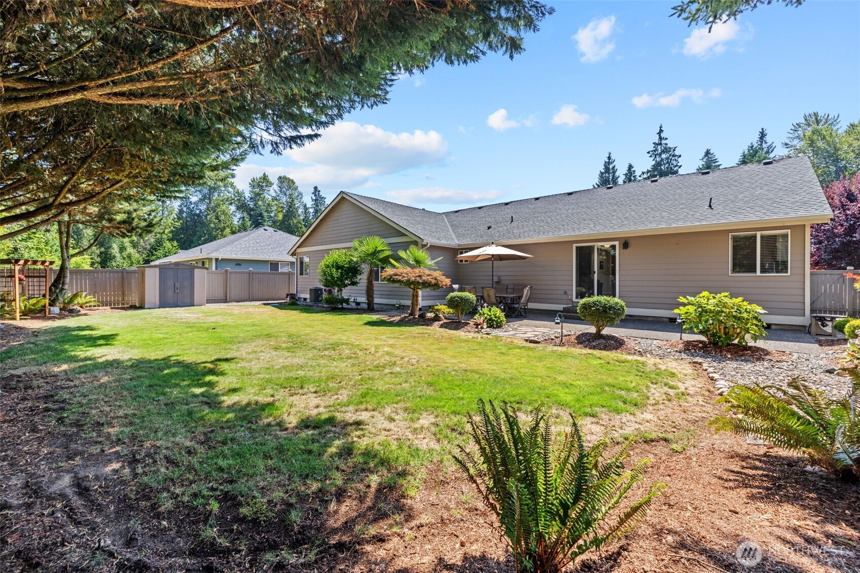 Back of home elevation, defined landscape and plantings. Storage shed and trellis.