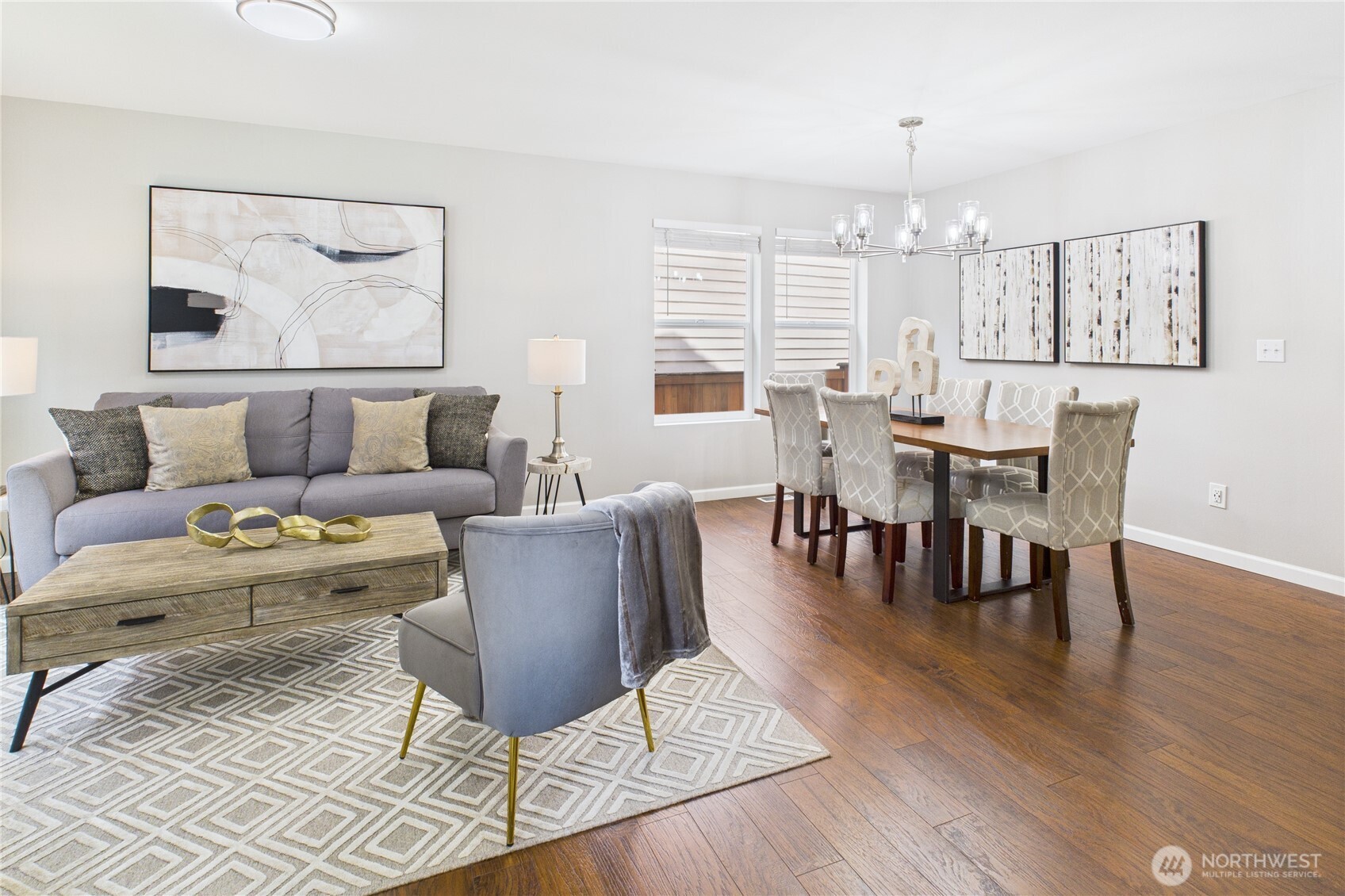 This beautifully staged open-concept living and dining space offers the perfect blend of function and style. Rich hardwood floors, large windows, and designer lighting set the tone for everyday comfort and effortless entertaining.