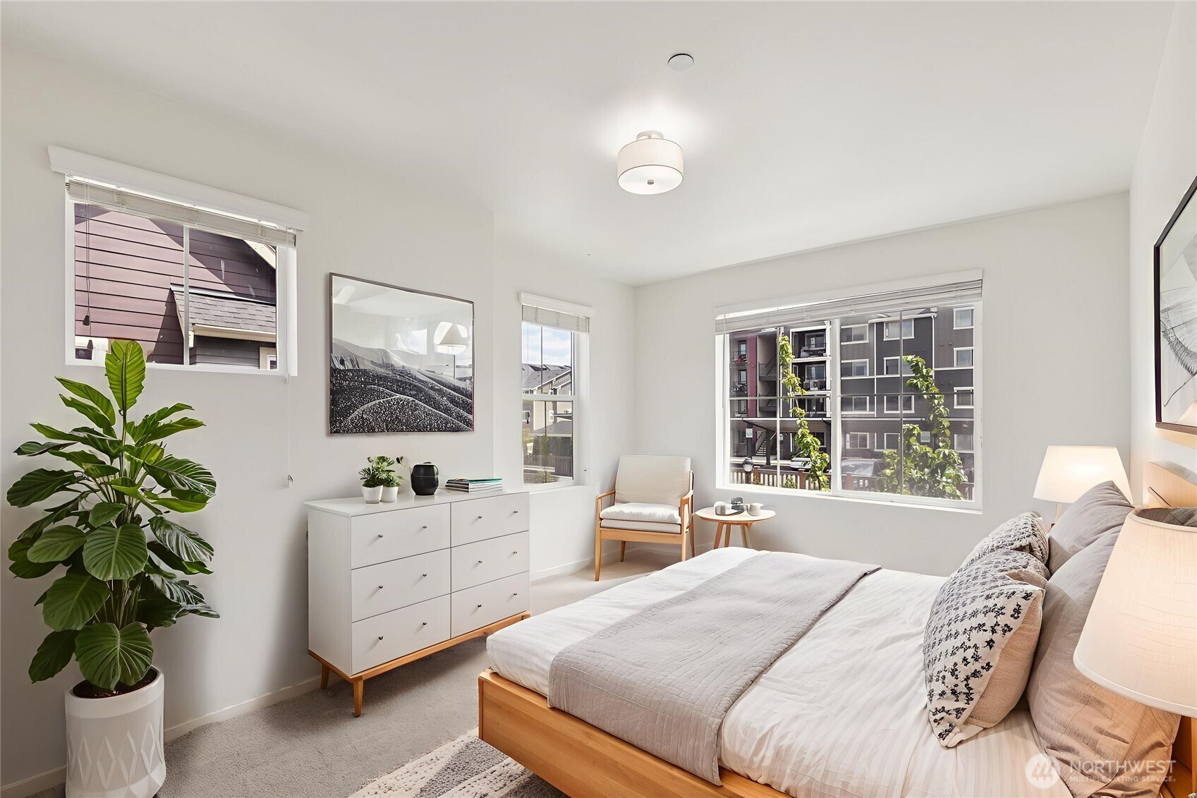 Corner bedroom features dual windows that fill the space with natural light, creating a bright and airy atmosphere throughout the day.