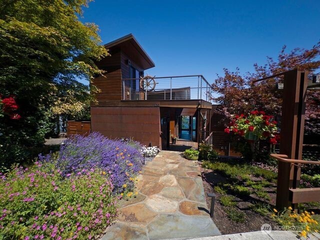 Primary entrance to main house on 630 Harrison Street is bordered by majestic flowers carefully selected. Building in forefront is a Bonus building for arts, crafts.  ng