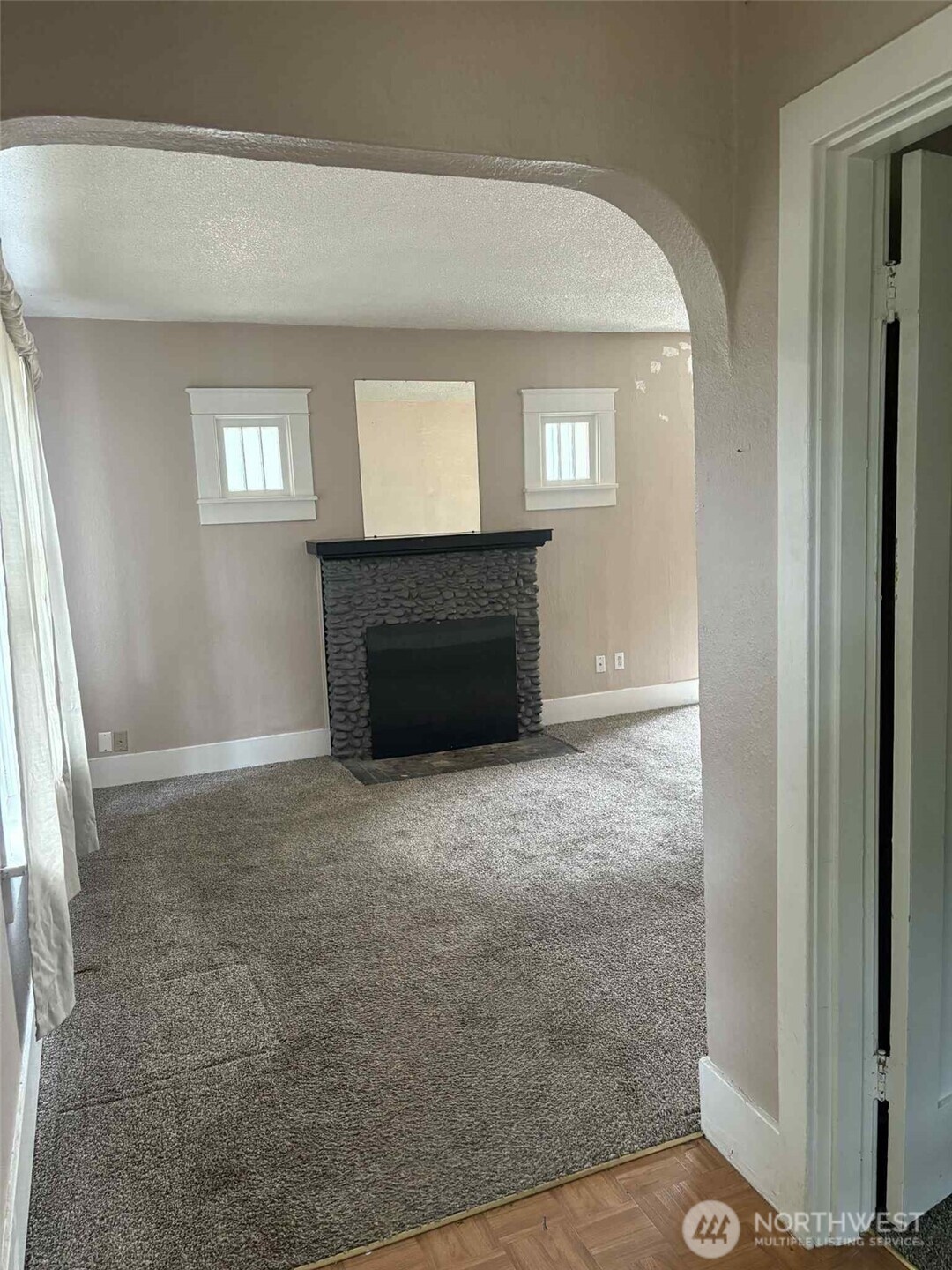 From the foyer you see the beautiful arches, the charm of the small windows accentuating the wood-burning fireplace.