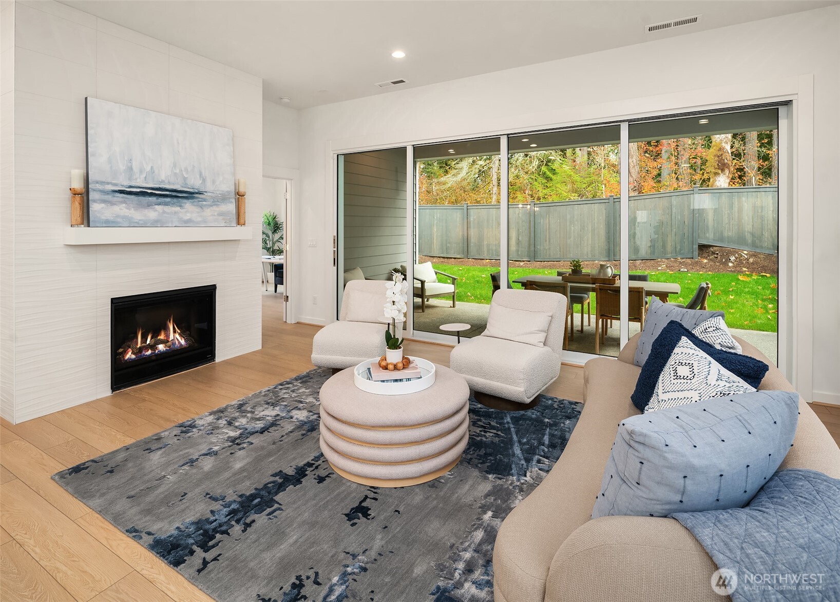 Great room with floor to ceiling tile fireplace and multi-stack doors open to covered patio