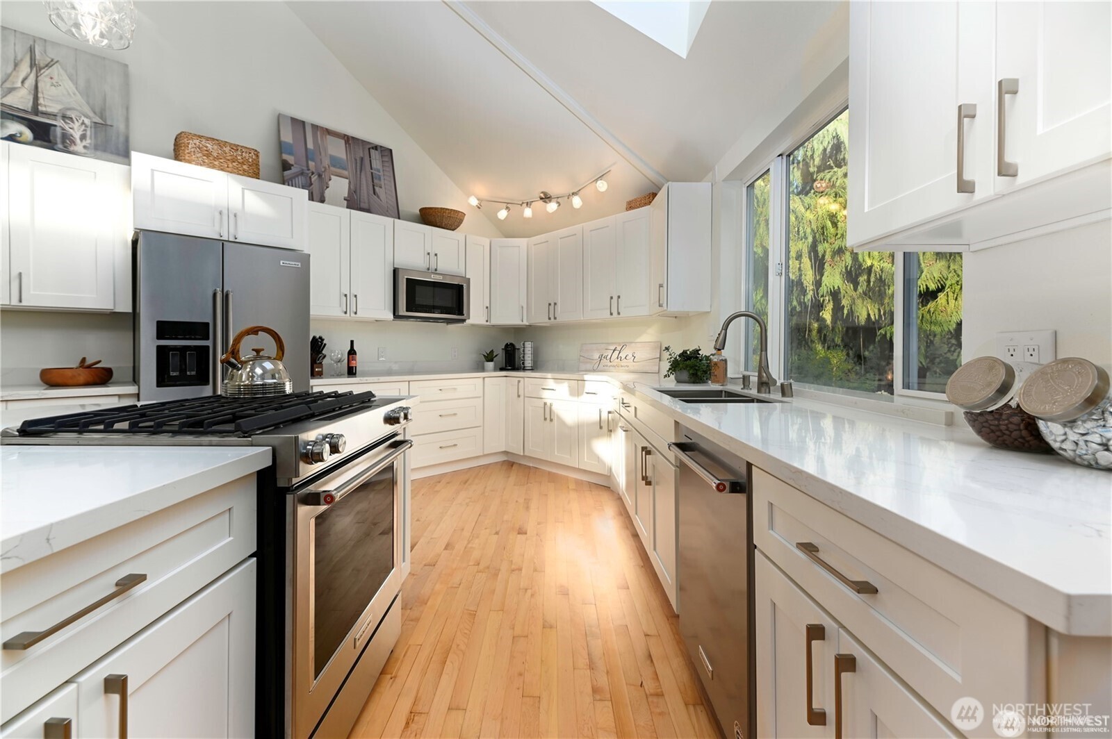 The gourmet kitchen's is designed with new sleek quartz countertops, custom cabinets and island, custom lights, stainless steel appliances, and features warm rich hardwood floors.