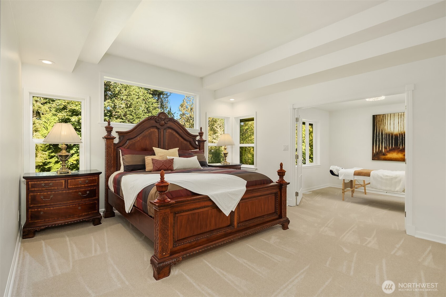 Master bedroom/primary suite boasts custom lighting, luxurious carpet, stunning cove ceilings and an abundance of natural light, creating a serene and elegant retreat.