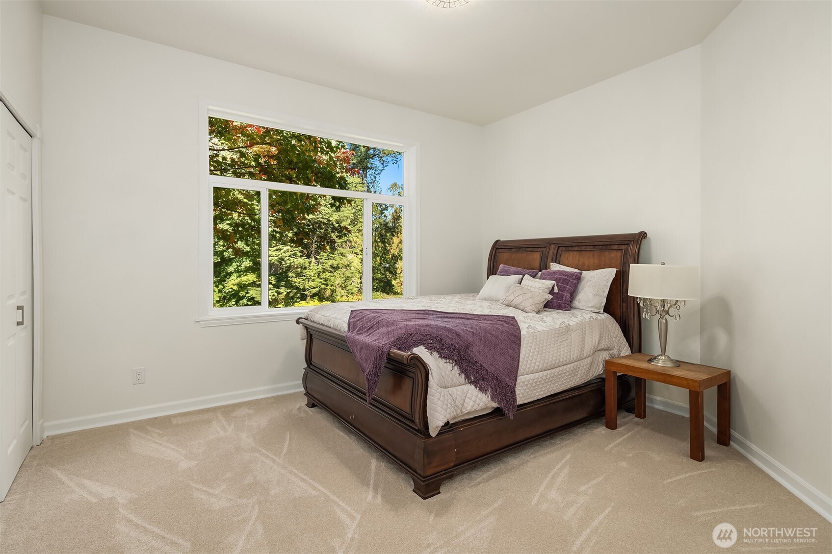 Second of four additional bedrooms on the main level offers peaceful views of the park-like setting and sport court - perfect for enjoying natural light and outdoor scenery.