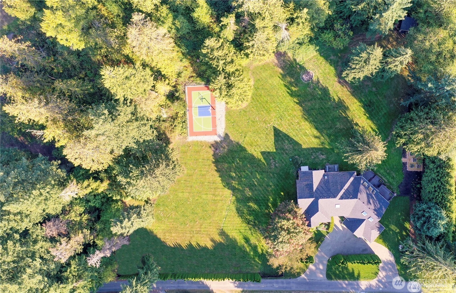 Aerial view of the beautiful, completely remodeled estate - a spacious equestrian retreat on 5-acres featuring a full-size sports court - perfect for recreation, relaxation, and room to roam.